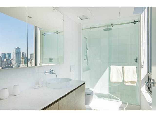 Bright bathroom with large windows, city view, and modern glass shower. - 1901 - 1171 Jervis St, Vancouver Downtown