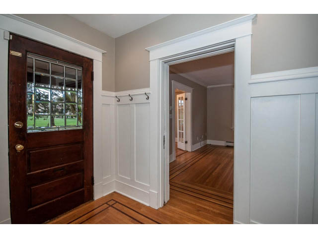 Bright entryway with hardwood floors and white wainscoting, leading into a spacious living area. - 769 West 20th Ave, Vancouver West Side