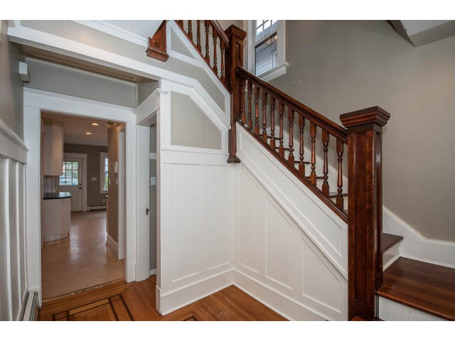 Staircase with wooden banister and white paneling leading to upper level. - 769 West 20th Ave, Vancouver West Side