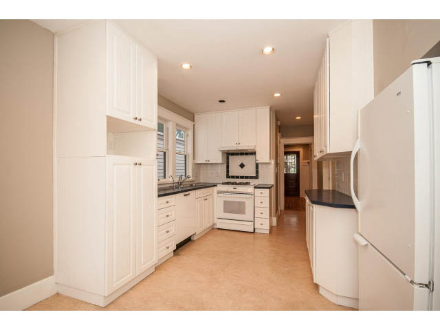 Bright kitchen with white cabinetry, granite countertops, and hardwood floors. - 769 West 20th Ave, Vancouver West Side