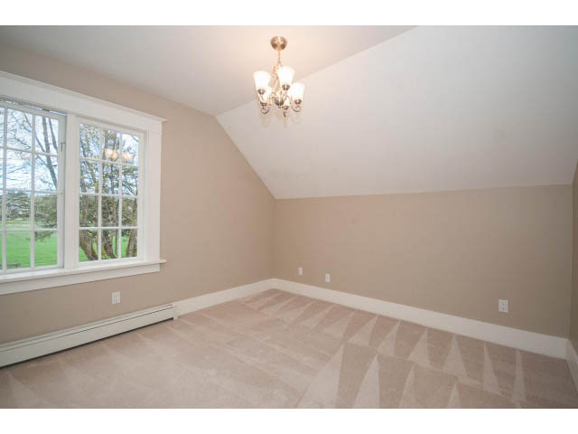 Bright living room with large windows and a chandelier, showcasing a serene outdoor view. - 769 West 20th Ave, Vancouver West Side