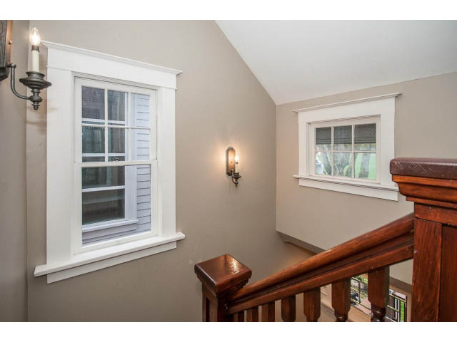 Staircase leading to upper level with wooden railings and large windows. - 769 West 20th Ave, Vancouver West Side