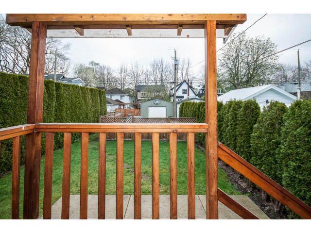 Furnished patio with wooden pergola and lush green hedge backdrop. - 769 West 20th Ave, Vancouver West Side