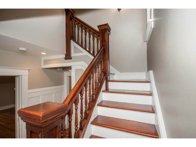 Staircase with wooden banister and white risers leading to upper level. - 769 West 20th Ave, Vancouver West Side