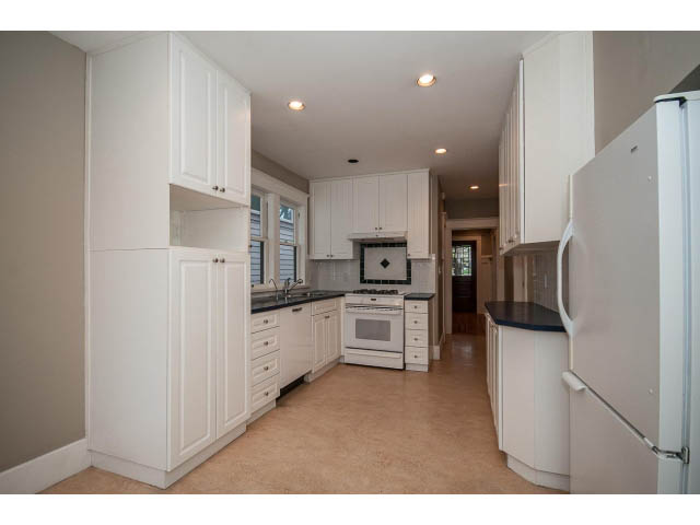 Bright kitchen with white cabinets, granite countertops, and hardwood floors. - 769 West 20th Ave, Vancouver West Side