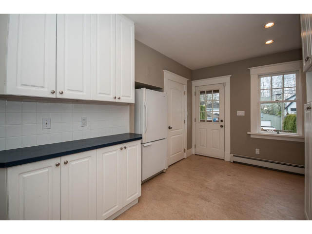 Bright kitchen with white cabinets, black countertops, and a city view. - 769 West 20th Ave, Vancouver West Side
