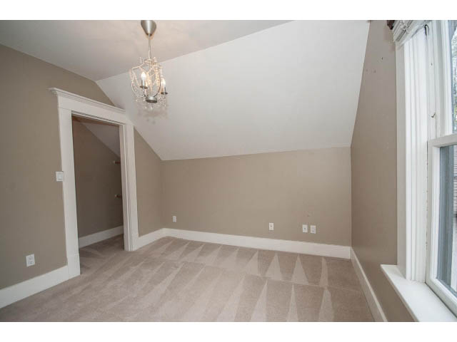Bright living room with beige walls, hardwood floors, and a chandelier. - 769 West 20th Ave, Vancouver West Side