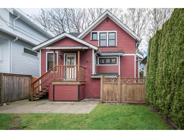 Bright living room with red exterior, wooden deck, and lush greenery. - 769 West 20th Ave, Vancouver West Side