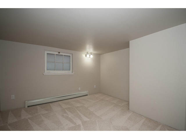 Empty living room with geometric carpet and small window. - 769 West 20th Ave, Vancouver West Side