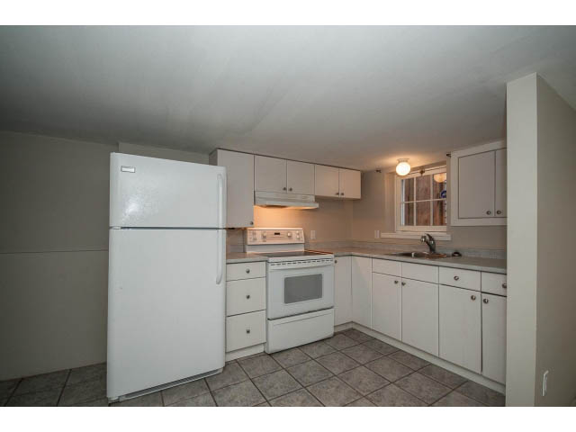 Bright kitchen with white cabinets, tiled floor, and a retro refrigerator. - 769 West 20th Ave, Vancouver West Side