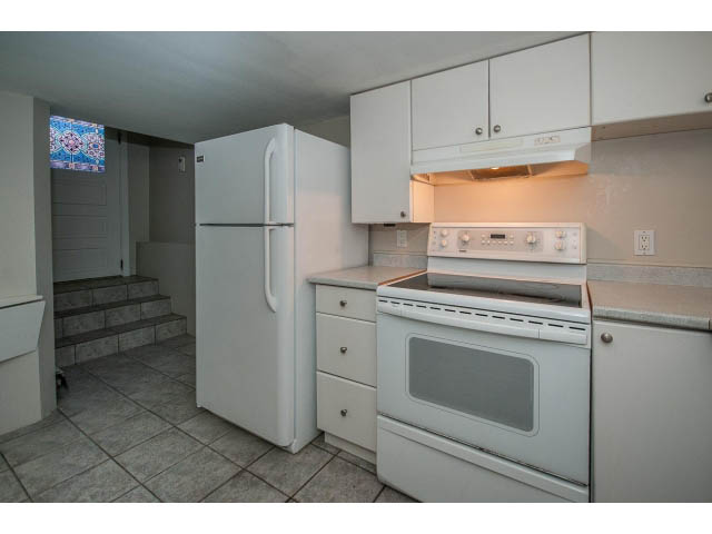 Bright kitchen with white appliances and tiled floors. - 769 West 20th Ave, Vancouver West Side