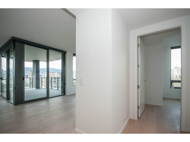 Bright living room with hardwood floors and sliding glass doors leading to a balcony. - 804 - 1171 Jervis St, Vancouver Downtown