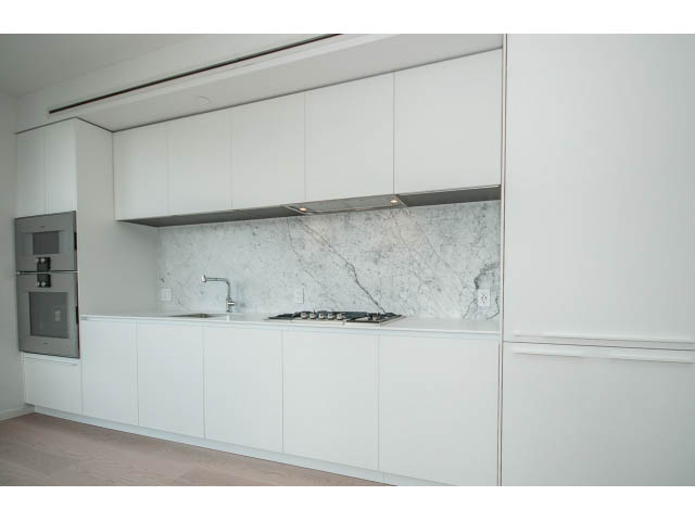 Bright kitchen with white cabinets, marble backsplash, and stainless steel appliances. - 804 - 1171 Jervis St, Vancouver Downtown
