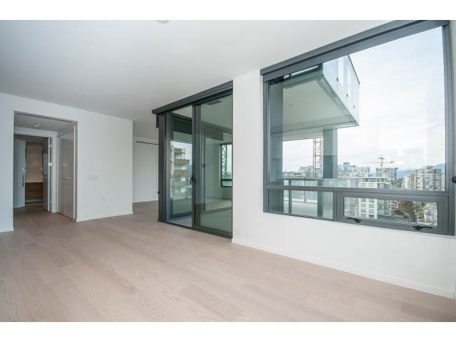 Spacious living room with hardwood floors and large windows offering a city view. - 804 - 1171 Jervis St, Vancouver Downtown