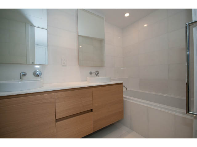 Modern bathroom with white tiles and wooden vanity. - 804 - 1171 Jervis St, Vancouver Downtown