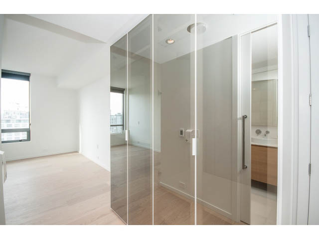 Bright living room with hardwood floors and large windows, showcasing a city view. - 804 - 1171 Jervis St, Vancouver Downtown