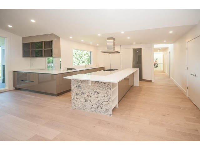 Bright kitchen with granite countertops and hardwood floors, leading to a spacious living area. - 5235 Headland Dr., West Vancouver