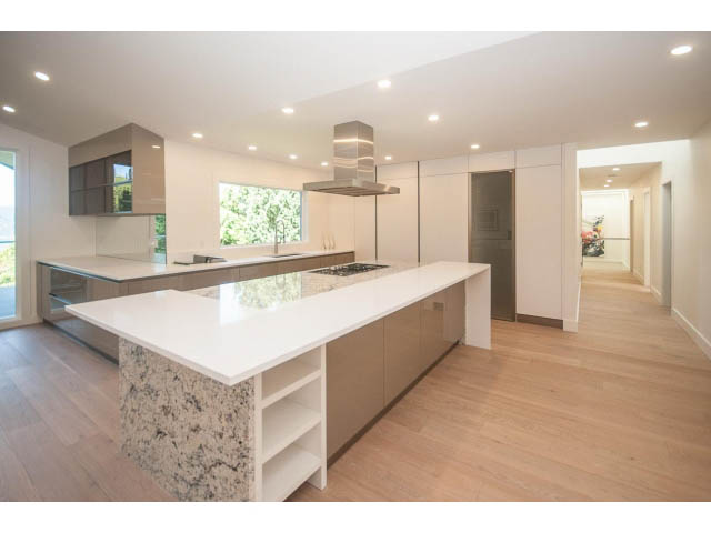 Bright kitchen with white cabinetry, granite countertops, and hardwood floors. - 5235 Headland Dr., West Vancouver