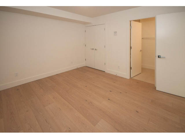 Empty living room with hardwood floors and white walls. - 5235 Headland Dr., West Vancouver