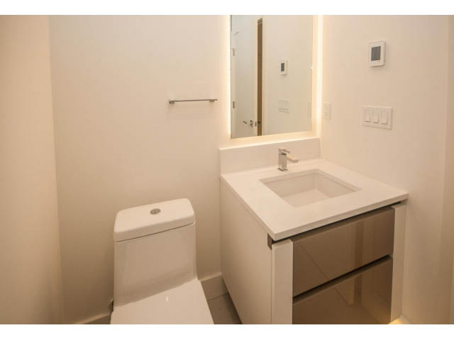 Modern bathroom with white vanity and large mirror. - 5235 Headland Dr., West Vancouver