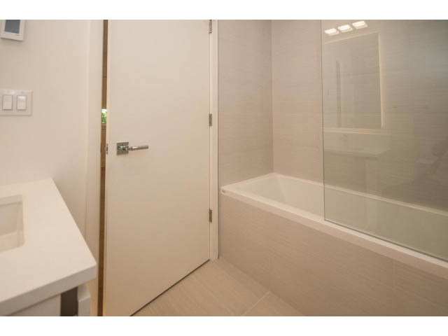 Modern bathroom with white countertop and glass shower door. - 5235 Headland Dr., West Vancouver