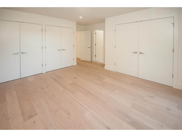 Bright hallway with white doors and light wood flooring. - 5235 Headland Dr., West Vancouver