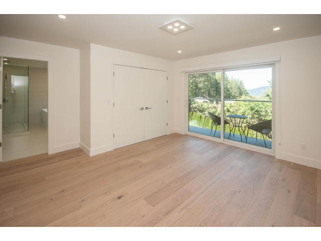 Spacious living room with hardwood floors and sliding glass doors leading to a balcony. - 5235 Headland Dr., West Vancouver