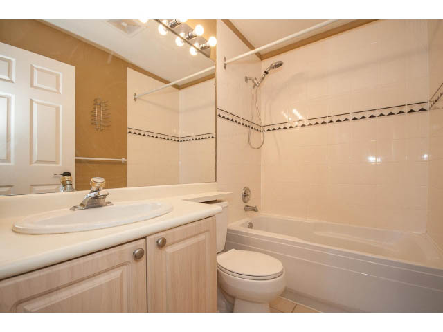 Furnished bathroom with white countertop and bathtub, modern fixtures. - 204 - 630 Roche Point Drive, North Vancouver