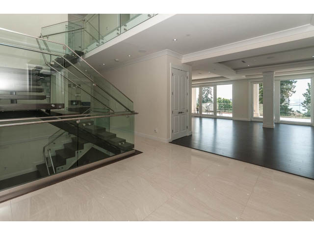 Spacious living room with glass staircase and large windows. - 2333 Mathers Ave, West Vancouver