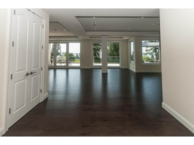 Bright living room with hardwood floors and large windows offering a city view. - 2333 Mathers Ave, West Vancouver