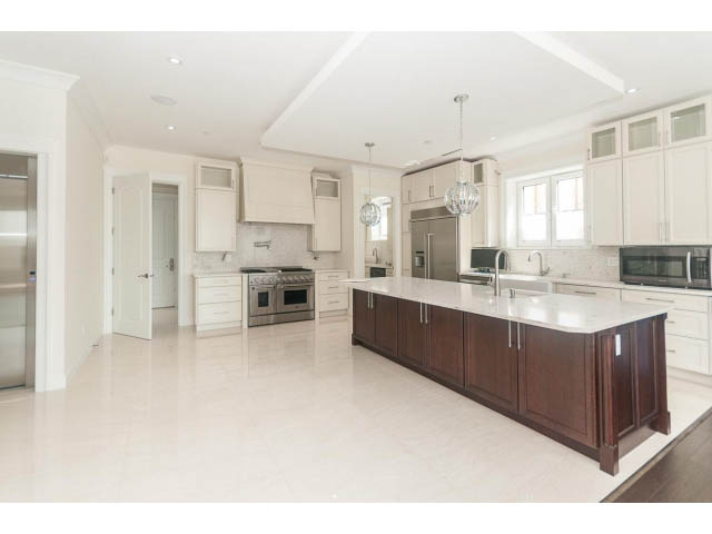 Bright kitchen with white marble countertops and dark wood cabinets, spacious and modern. - 2333 Mathers Ave, West Vancouver