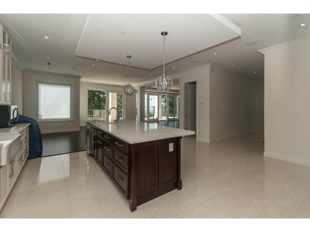 Bright kitchen with marble countertops and glossy white floors, showcasing a spacious and modern design. - 2333 Mathers Ave, West Vancouver