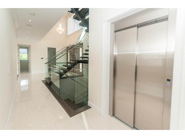 Modern elevator with sleek glass doors and polished stainless steel panels. - 2333 Mathers Ave, West Vancouver