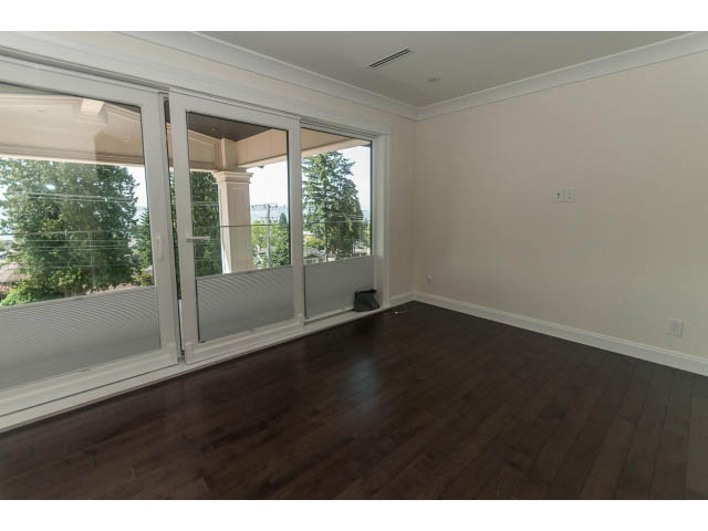 Spacious living room with hardwood floors and large windows offering a city view. - 2333 Mathers Ave, West Vancouver