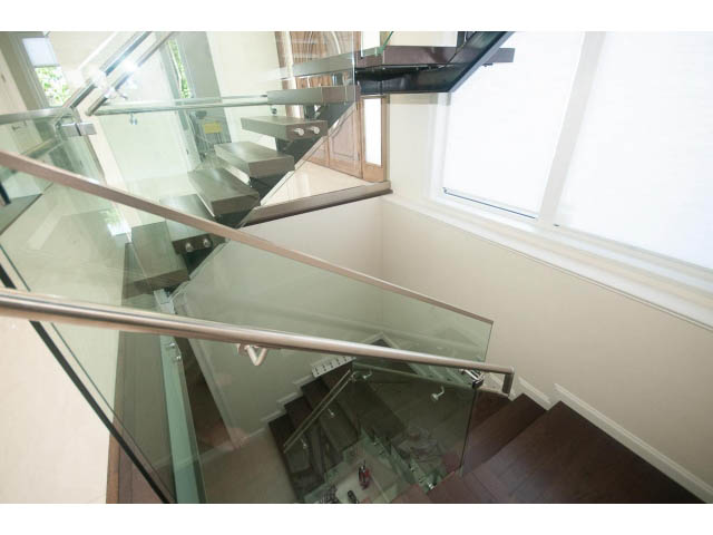 Staircase with glass railings and hardwood floors. - 2333 Mathers Ave, West Vancouver