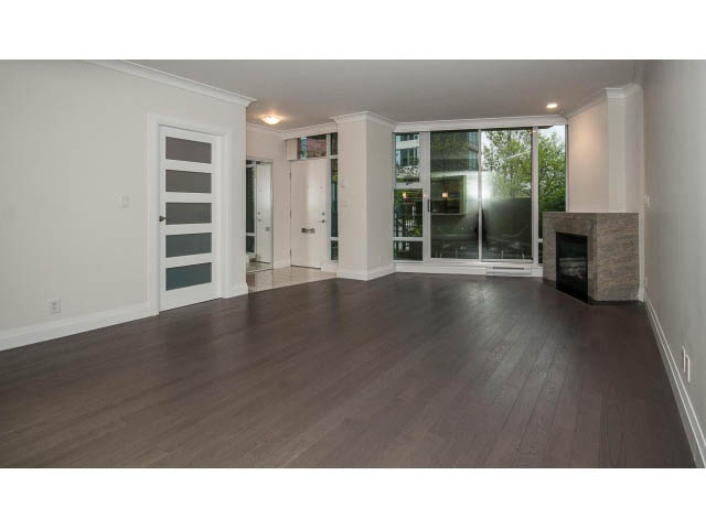 Bright living room with hardwood floors and large sliding glass doors leading to a city view. - 21 Smithe Mews, Vancouver Downtown