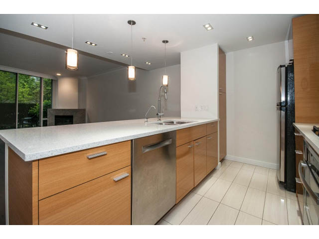 Bright kitchen with white countertops, wooden cabinets, and a city view. - 21 Smithe Mews, Vancouver Downtown