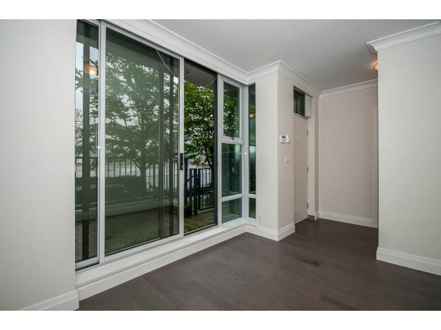 Spacious living room with hardwood floors and large sliding glass doors leading to a balcony. - 21 Smithe Mews, Vancouver Downtown
