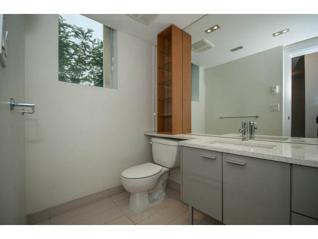 Bright bathroom with granite countertops and wooden cabinets, featuring a city view. - 21 Smithe Mews, Vancouver Downtown
