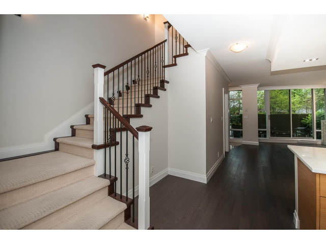 Furnished living room with hardwood floors and a view of greenery outside. - 21 Smithe Mews, Vancouver Downtown