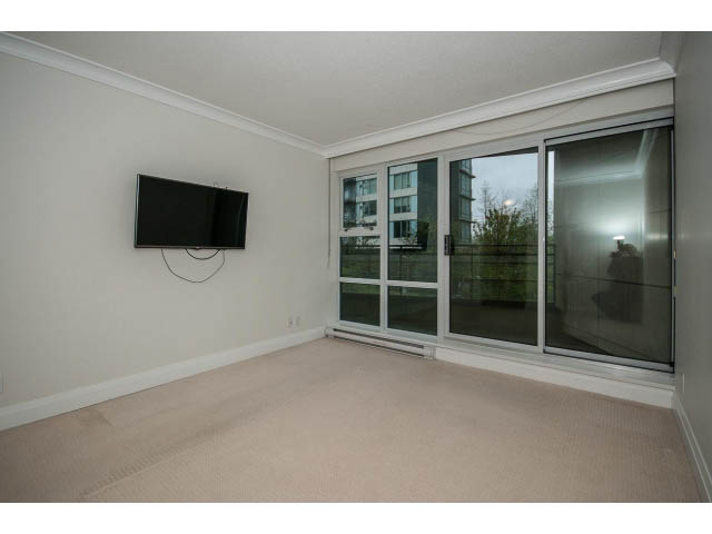 Spacious living room with large windows, city view, and wall-mounted TV. - 21 Smithe Mews, Vancouver Downtown