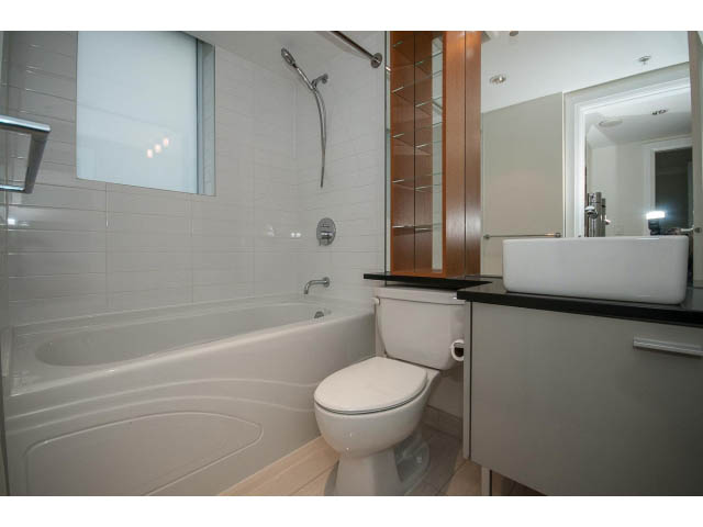 Modern bathroom with sleek white fixtures, large mirror, and built-in shelving. - 21 Smithe Mews, Vancouver Downtown