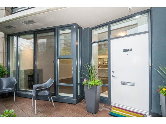 Furnished patio with glass doors, potted plants, and colorful rug. - 21 Smithe Mews, Vancouver Downtown