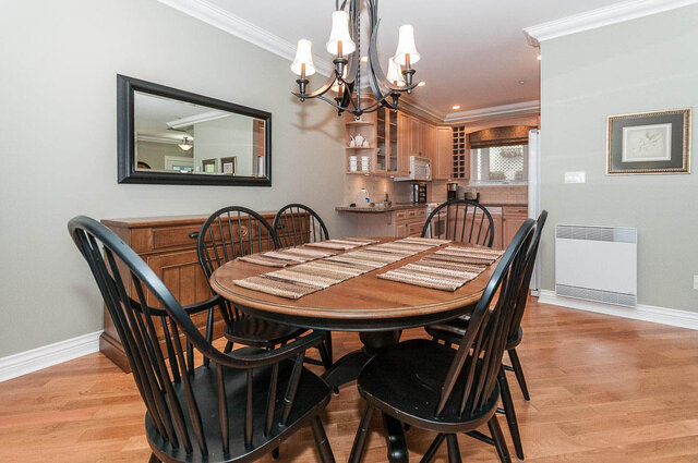Spacious dining room with hardwood floors, a large wooden table, and a chandelier, perfect for gatherings. - 2031 Creelman Ave, Vancouver West Side
