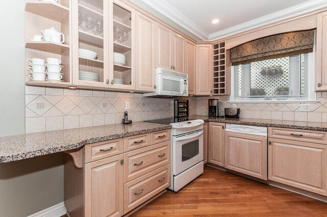 Bright kitchen with granite countertops, hardwood floors, and a window with blinds. - 2031 Creelman Ave, Vancouver West Side