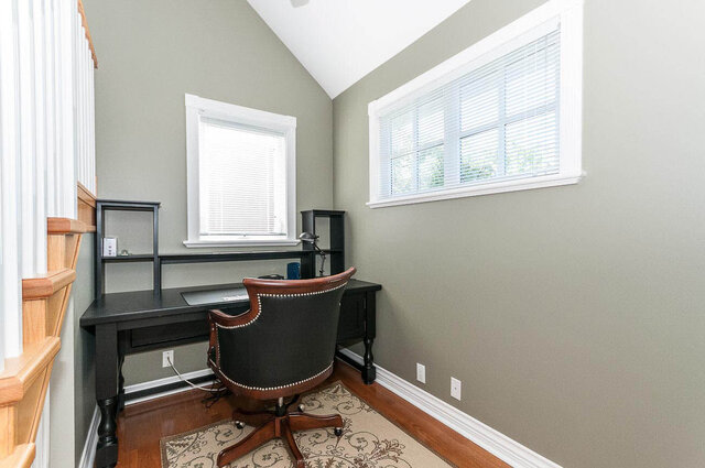 Spacious home office with dark wood desk, patterned rug, and large windows. - 2031 Creelman Ave, Vancouver West Side