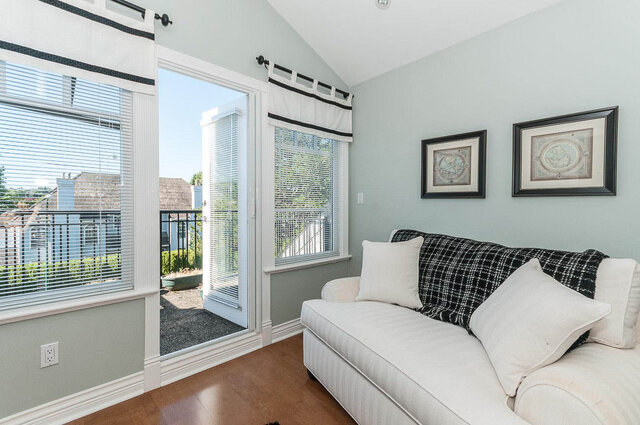 Bright living room with white couch, black and white plaid throw, and framed nautical art. - 2031 Creelman Ave, Vancouver West Side