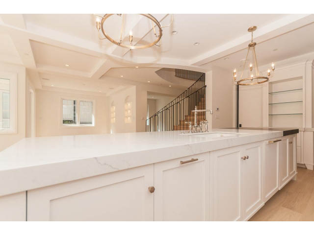 Bright kitchen with white marble countertops, hardwood floors, and a chandelier. - 6448 Argyle Ave, West Vancouver