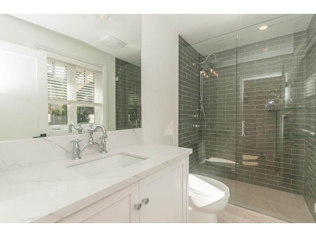 Bright bathroom with white marble countertop and gray subway tile shower. - 6448 Argyle Ave, West Vancouver