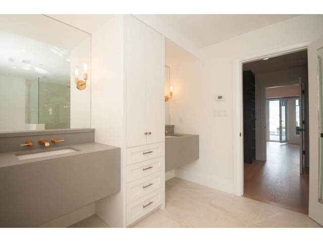 Modern bathroom with sleek countertop and white cabinetry. - 6448 Argyle Ave, West Vancouver